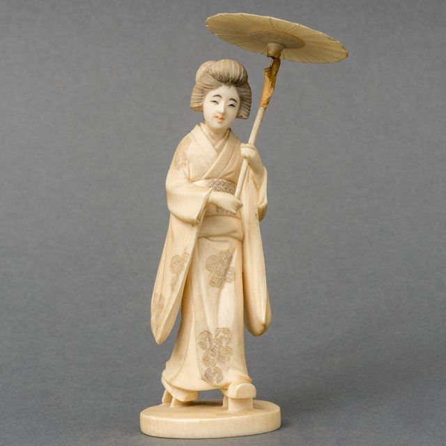 Japanse School, 19e eeuw   | Okimono van een vrouw in kimono met een parasol in haar hand, ivoor 13,0 cm